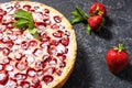 Homemade strawberry custard tart decorated with strawberry on black stone background