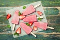 Homemade strawberry ice cream or popsicles on rustic table, frozen fruit juice, top view Royalty Free Stock Photo