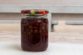 Homemade strawberry jam in a glass jar with a colored lid on the table. The concept of a healthy diet, home cooking meal Royalty Free Stock Photo