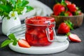 Homemade strawberry jam in a glass jar with fresh strawberries on a dark wooden background. Rustic style. Horizontal orientation Royalty Free Stock Photo