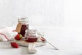 Homemade strawberry jam or marmalade in the glass jars and ripe strawberries on the wooden board on white background. Side view, Royalty Free Stock Photo