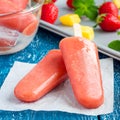 Homemade strawberry mango popsicles on a wooden table, square Royalty Free Stock Photo