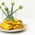 Homemade Stuffed crepes on a plate on white background.