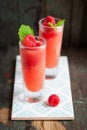 Homemade summer cold raspberry cocktail with crushed iced and alcohol in glasses on a vintage background