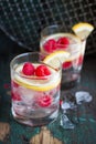 Homemade summer cold raspberry lemon cocktail with sparkling water and crushed iced in glasses on a vintage background Royalty Free Stock Photo