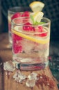 Homemade summer cold raspberry lemon cocktail with sparkling water and crushed iced in glasses on a vintage background Royalty Free Stock Photo