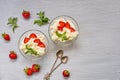 Homemade summer dessert with sliced strawberries and cream cheese in the glass bowls on a gray background with copy space Royalty Free Stock Photo