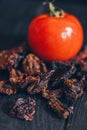 Homemade sun-dried red tomato slices on dark background. Cooking process traditional Italian Mediterranean cuisine Royalty Free Stock Photo