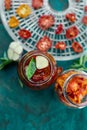 Homemade sun dried tomatoes with herbs, garlic in olive oil in a glass jar on dark green background. Copy space, close up. Royalty Free Stock Photo