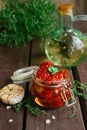 Homemade sun-dried tomatoes in oil with fresh herbs thyme, oregano, garlic in a glass jar Royalty Free Stock Photo