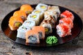 Homemade sushi with salmon, tobiko caviar, omelet, cucumber, sesame and soft cheese on old wooden background. Rustic style. Royalty Free Stock Photo