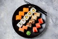 Homemade sushi with salmon, tobiko caviar, omelet, cucumber, sesame and soft cheese on old wooden background. Rustic style. Royalty Free Stock Photo