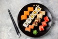 Homemade sushi with salmon, tobiko caviar, omelet, cucumber, sesame and soft cheese on old wooden background. Rustic style. Royalty Free Stock Photo