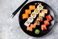 Homemade sushi with salmon, tobiko caviar, omelet, cucumber, sesame and soft cheese on old wooden background. Rustic style. Royalty Free Stock Photo