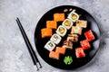 Homemade sushi with salmon, tobiko caviar, omelet, cucumber, sesame and soft cheese on old wooden background. Rustic style. Royalty Free Stock Photo