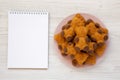 Homemade Sweet Bear Cookies on a pink plate, blank notepad on a white wooden background, top view. From above, flat lay, overhead