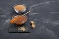 Homemade sweet caramel sauce in glass bowl and brown cane sugar with sugar crystal stick on black slate board Royalty Free Stock Photo