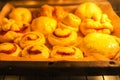 Homemade sweet cinnamon roll baking on a sheet in oven