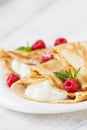 Homemade sweet crepes with cottage cheese, mint and raspberry