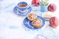 Homemade sweet muffins with almonds for breakfast. Tea and a glass of water in vintage blue dishes. Fruit and oil. Free space for