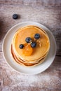 Homemade sweet pancakes with blueberries, fruit jam and honey