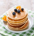 Homemade sweet pancakes with blueberries, fruit jam and honey