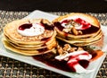 Homemade sweet pancakes with fruit jam, sour cream on a white plate. Breakfast with stack topped blueberry jam and Royalty Free Stock Photo