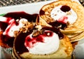 Homemade sweet pancakes with fruit jam, sour cream on a white plate. Breakfast with stack topped blueberry jam and Royalty Free Stock Photo