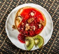 Homemade sweet pancakes with raspberry jam on a white plate. Breakfast with stack topped blueberry jam, walnuts and kiwi Royalty Free Stock Photo