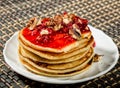 Homemade sweet pancakes with raspberry jam on a white plate. Breakfast with stack topped blueberry jam, walnuts and kiwi Royalty Free Stock Photo