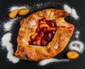 Homemade sweet plum open pie on black stone background