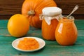 Homemade sweet pumpkin jam in white plate and in glass jars with