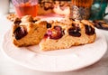 Homemade sweet round plum cake New York Times cutted on plate with cups, glasses of tea, coffee at back on holyday Breakfast or bi Royalty Free Stock Photo