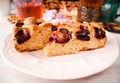 Homemade sweet round plum cake New York Times cutted on plate with cups, glasses of tea, coffee at back on holyday Breakfast or bi Royalty Free Stock Photo