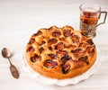 Homemade sweet round plum cake New York Times on white plate with of tea in metal cup holder and silver on family Breakfast or bir Royalty Free Stock Photo