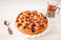 Homemade sweet round plum cake New York Times on white plate with of tea in metal cup holder and silver on family Breakfast or bir Royalty Free Stock Photo