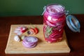 Homemade sweet and spicy pickled red onions sliced in a large glass jar, with the ingredients beside Royalty Free Stock Photo