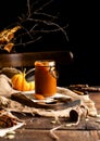 Homemade sweet and tasty pumpkin caramel n glass jar stands on wooden board