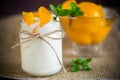 Homemade sweet yogurt with slices of pickled peaches in a glass jar