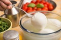 Table set with a bowl with buffalo mozzarella in the center and in the background the ingredients for the Mediterranean d