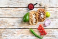 Homemade taco with chicken and beef near raw ingredients over white textured old table, top view with space for text