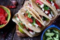 Homemade tacos with minced meat in tomato sauce with fresh tomatoes, cucumbers, chili and soft cheese. Mexican food. Royalty Free Stock Photo