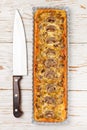Homemade tart with mushrooms, leek, cheese and thyme on white rustic background. Traditional snack cake and a knife on the table Royalty Free Stock Photo