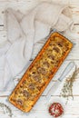 Homemade tart with mushrooms, leek, cheese and thyme on white rustic background. Traditional snack cake and a knife on the table Royalty Free Stock Photo