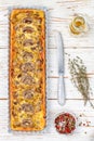 Homemade tart with mushrooms, leek, cheese and thyme on white rustic background. Traditional snack cake and a knife on the table Royalty Free Stock Photo
