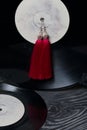 Homemade tassel earrings in red. Against the background of old vinyl records and brushed pine boards painted in black and white Royalty Free Stock Photo