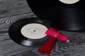 Homemade tassel earrings in red. Against the background of old vinyl records and brushed pine boards painted in black and white Royalty Free Stock Photo