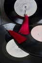 Homemade tassel earrings in red. Against the background of old vinyl records and brushed pine boards painted in black and white Royalty Free Stock Photo