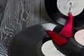 Homemade tassel earrings in red. Against the background of old vinyl records and brushed pine boards painted in black and white Royalty Free Stock Photo