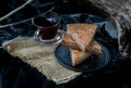 Homemade tasty banana cake slices on Black ceramic plate with Black coffee on sackcloth background Royalty Free Stock Photo